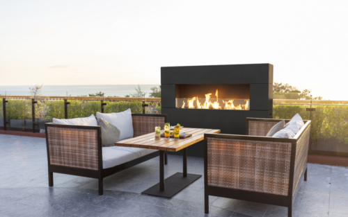 Milan Tall Fireplace with a cozy outdoor dining table.